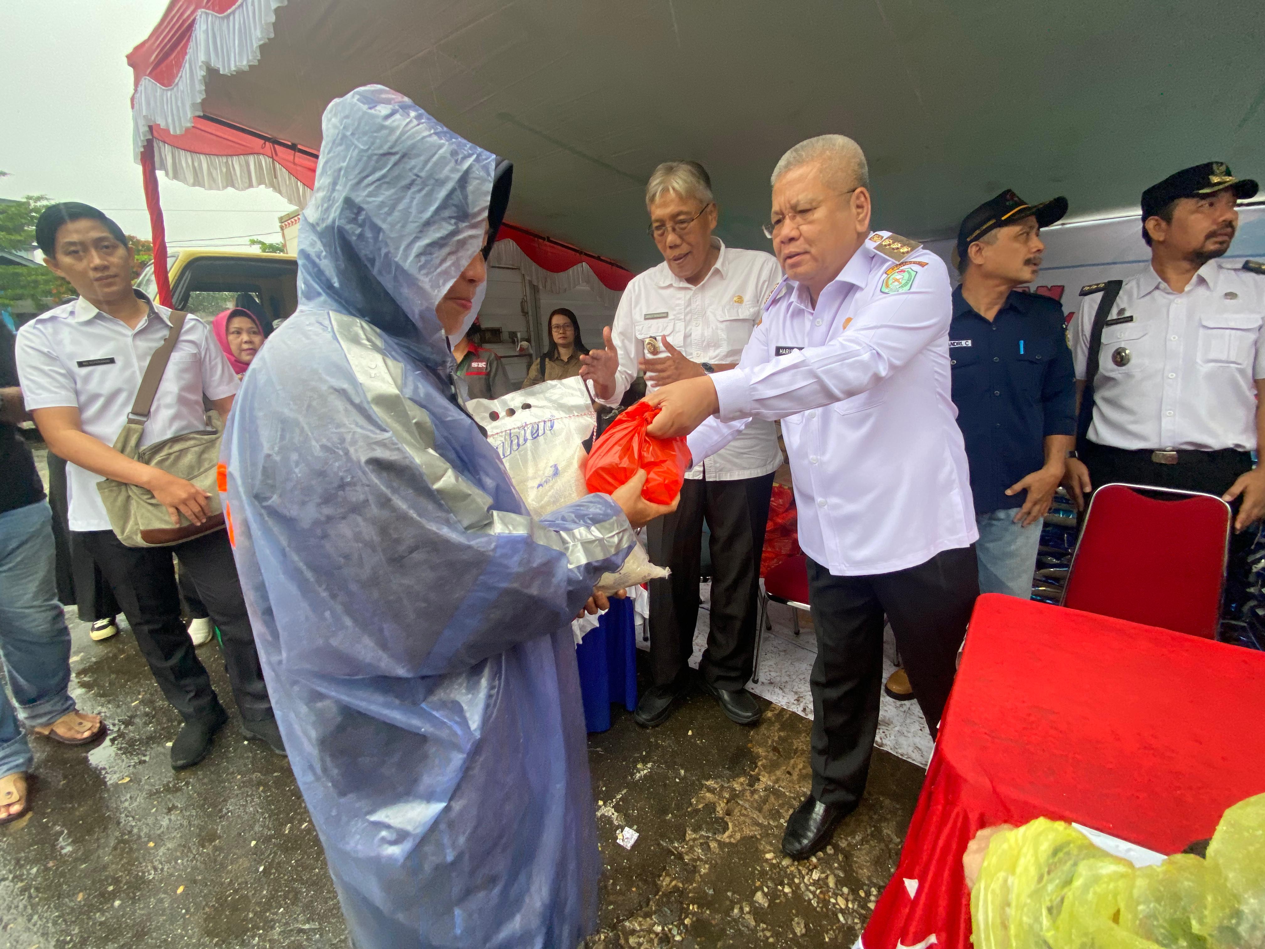 Diguyur Hujan, Harisson Buka Gerakan Pangan Murah di Pasar Raya Sintang