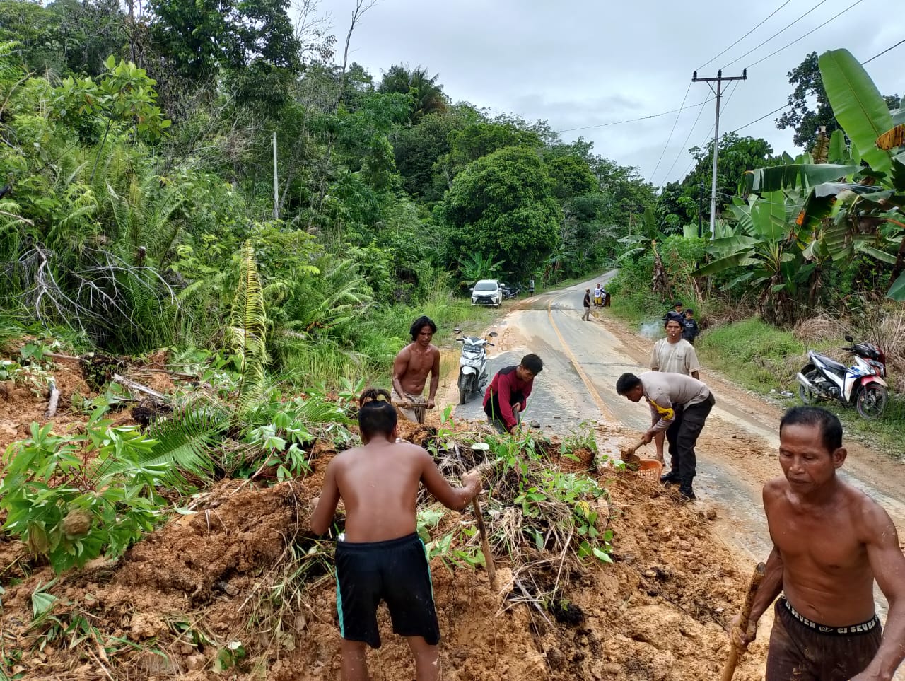 Personel Polsek Bunut Hulu dan Warga Gotong Royong Bersihkan Sisa Longsor di Ruas Jalan Nasional Dusun Muncin