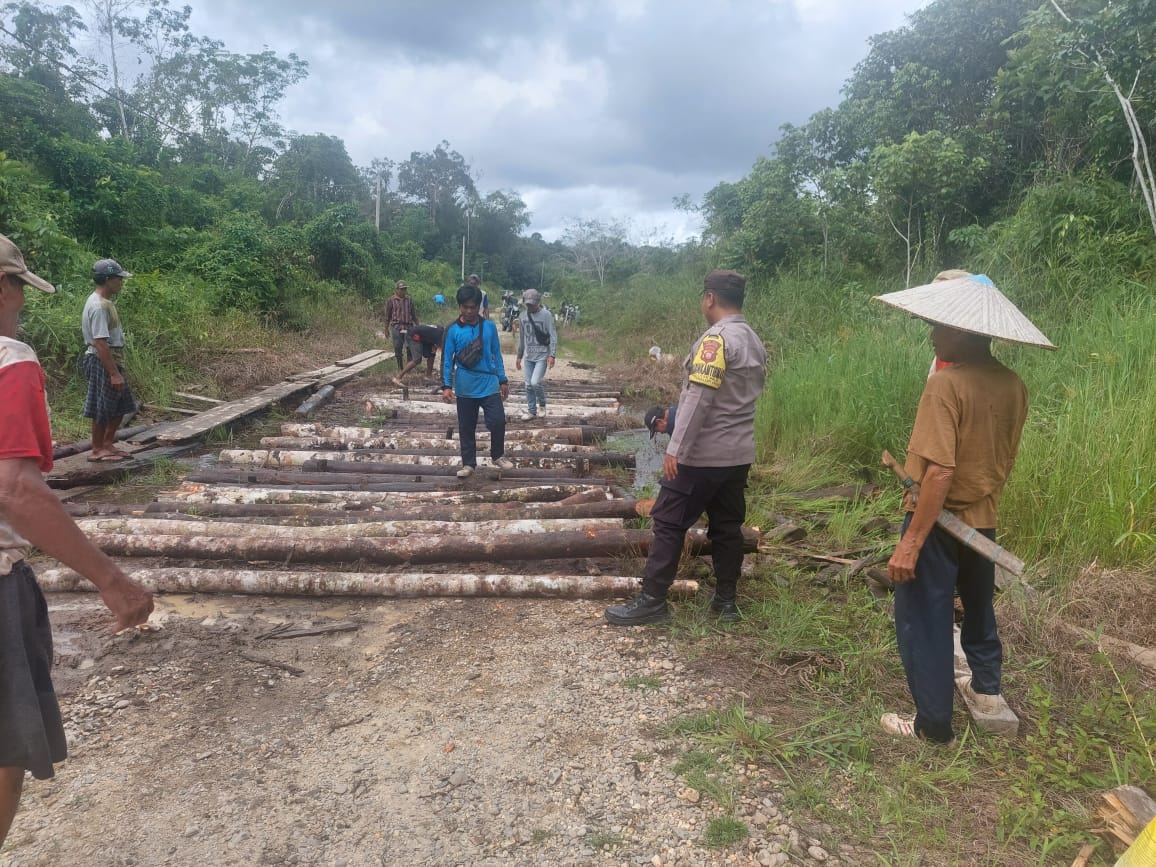 Bhabinkamtibmas Polsek Embaloh Hulu Bantu Warga Perbaiki Jalan Rusak di Desa Saujung Giling Manik