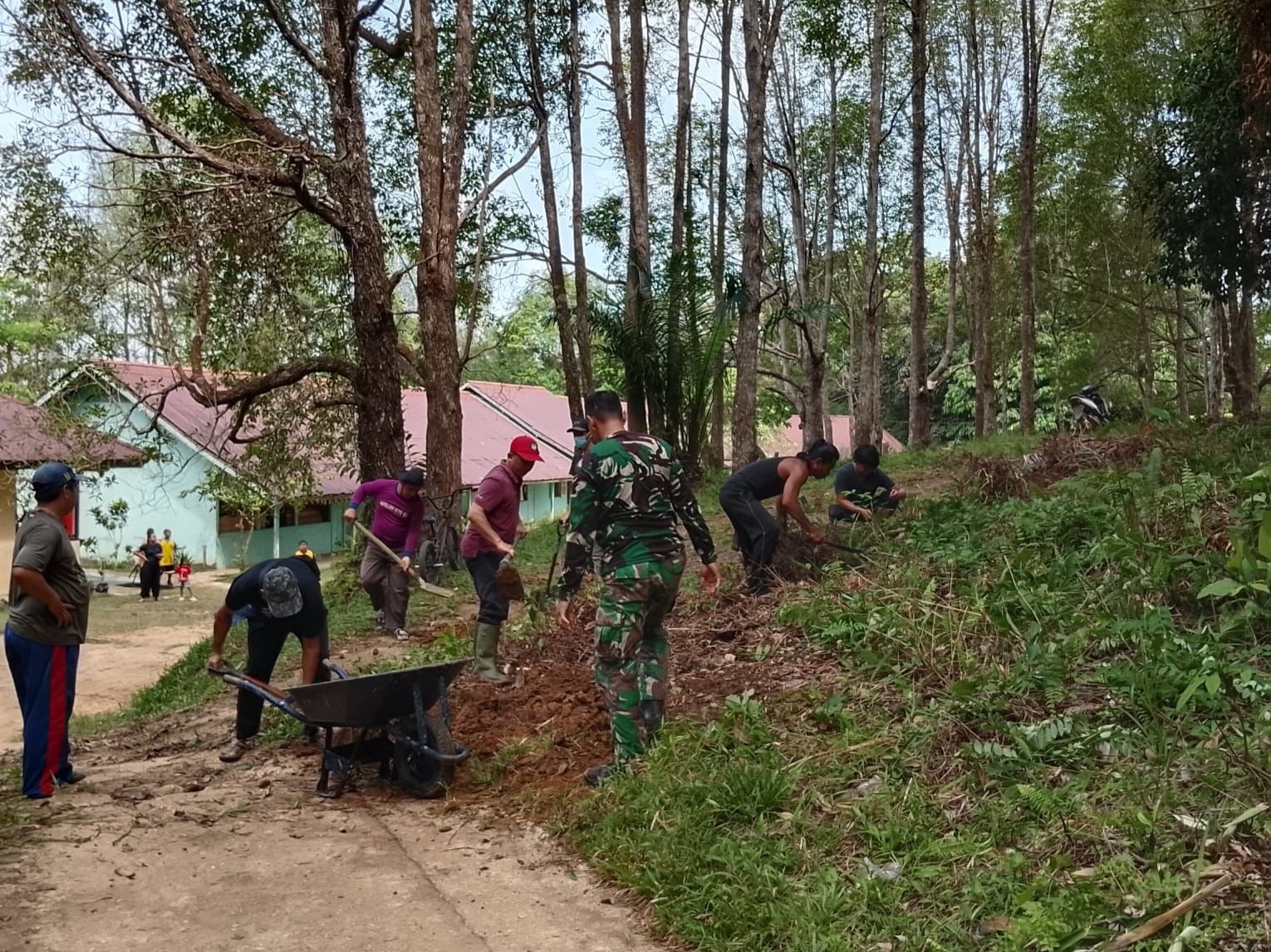 Babinsa Semitau bersama Masyarakat Gotong Royong Lakukan Pelebaran dan Perataan Jalan SD Pelita