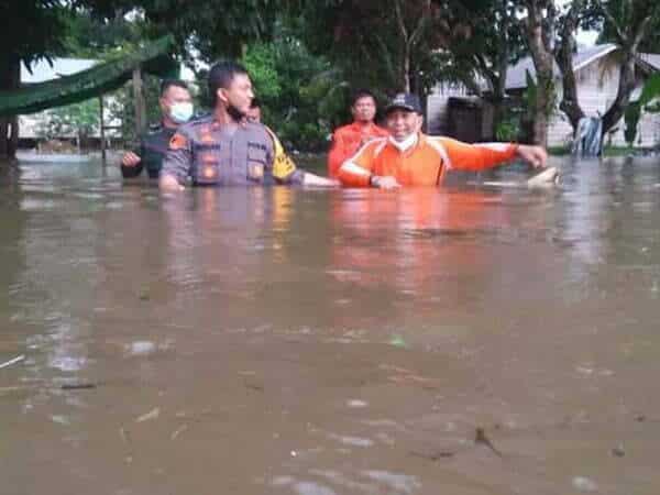 Kapolsek Sandai Rela Arungi Banjir untuk Berikan Bantuan Sembako ke Warga