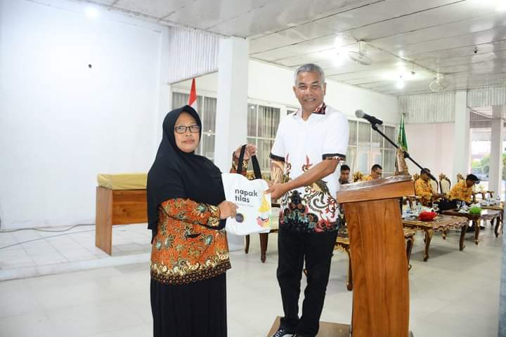 Bupati ketapang, Martin Rantan saat memberikan souvenir Napak Tilas kepada satu diantara guru tenaga kontrak. (Foto: Adi LC)