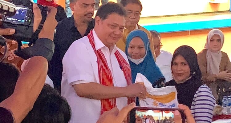 Menko Perekonomian, Airlangga Hartarto menyerahkan bantuan beras kepada salah satu penerima manfaat. (Foto: Indri)