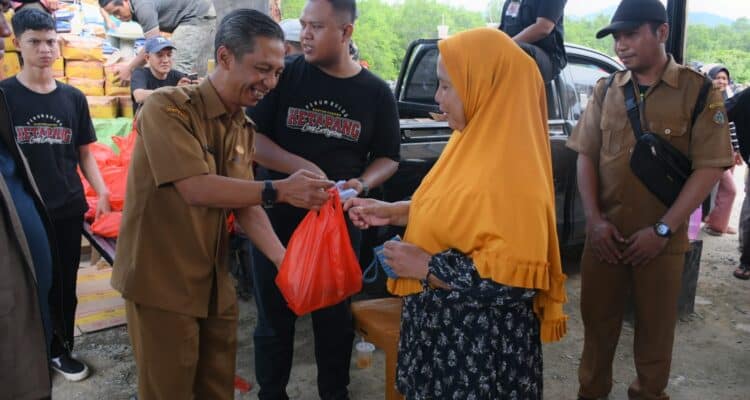 Pj Sekda KKU, Rene saat membagikan sembako di Pasar Rakyat, Kecamatan Sukadana, Selasa (06/02/2024). (Foto: Prokopim)