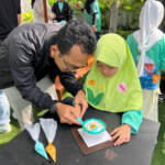 Salah seorang peserta Kids Playdate sedang menghias kue dengan Korean Style Cake bersama ayah dalam "Decorating Cake Class" PLN