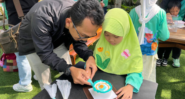 Salah seorang peserta Kids Playdate sedang menghias kue dengan Korean Style Cake bersama ayah dalam "Decorating Cake Class" PLN