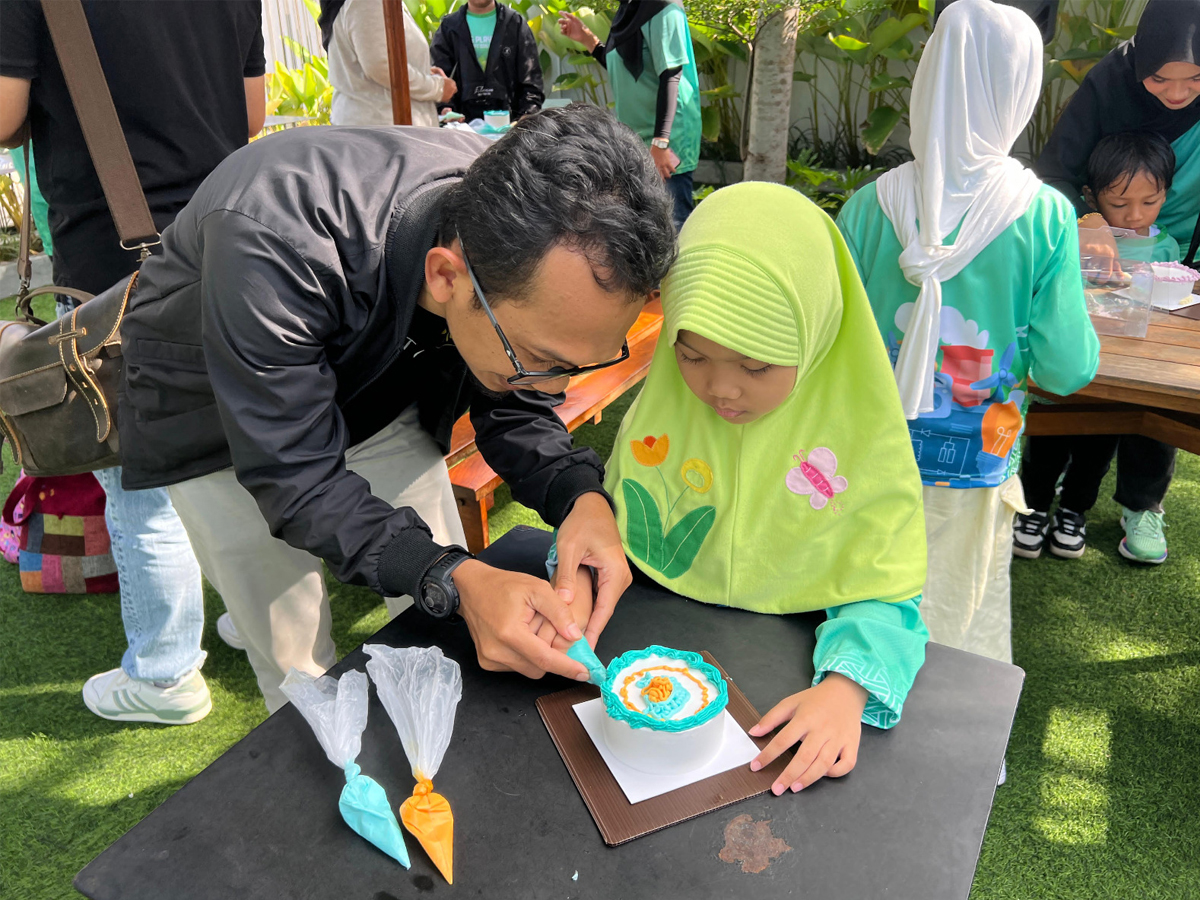 Salah seorang peserta Kids Playdate sedang menghias kue dengan Korean Style Cake bersama ayah dalam "Decorating Cake Class" PLN